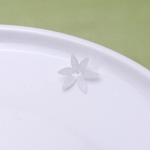Macro detail of a white frosted resin six-petal flower bead for DIY jewelry making