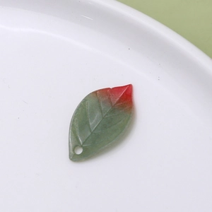 Macro shot of green and red gradient leaf charm with detailed veins for DIY jewelry making