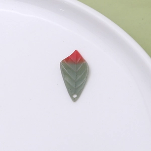 Macro detail of leaf-shaped resin pendant showing red-green gradient and vein texture