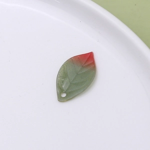 Macro shot of red-green gradient heat shrink leaf pendant with detailed vein patterns