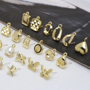Nahaufnahme von goldfarbenen Schmuckteilen mit Perlen und geometrischen Formen für DIY-Ohrringe