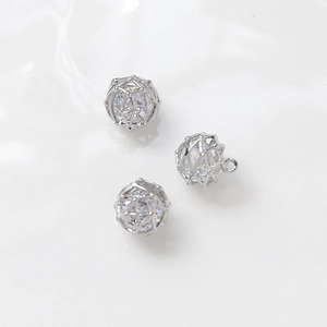 Macro view of three hollow silver wire cage pendants with embedded cubic zirconia stones