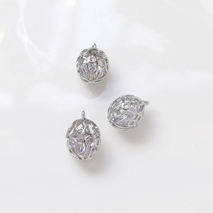 Macro view of white gold plated hollow metal cages with embedded teardrop zircons
