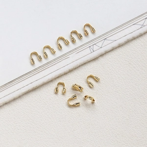 Macro shot of 14k gold-filled U-shape wire protectors for necklace and bracelet making