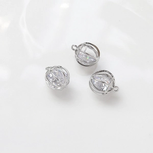 Detailed macro view of silver-plated copper hollow spherical charms with inset zircons