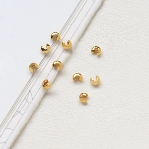 Macro shot of 14K gold plated C-shaped crimp cover beads for jewelry making