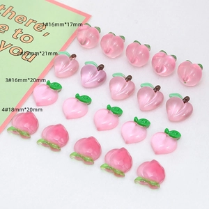 Detail view of pink resin peach charms in four sizes for DIY jewelry and hair accessories