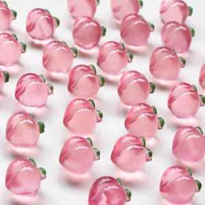 Macro detail of translucent pink peach resin charms with green leaves for DIY jewelry