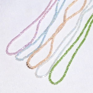 Macro detail of 3mm square faceted crystal beads for DIY jewelry making in macaron colors