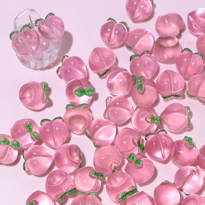 Macro view of pink resin peach charms for DIY jewelry and hair accessory making