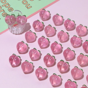 Detail of pink peach hair claw clips made of translucent resin with green leaves