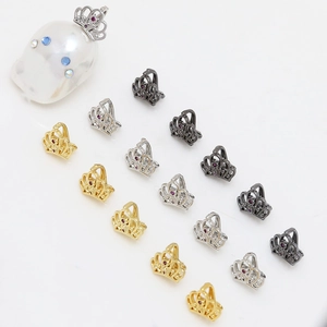 Detailed view of crown-shaped gold and silver jewelry fittings with red cubic zirconia stones