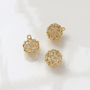 Detailed view of three gold plated spherical cages with embedded sparkling zircons for DIY