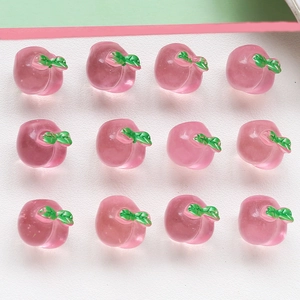 Macro view of 12 pieces pink resin peach charms with green leaves for DIY jewelry