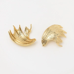 Detailed macro view of 18k gold plated devil wing charms for DIY jewelry making