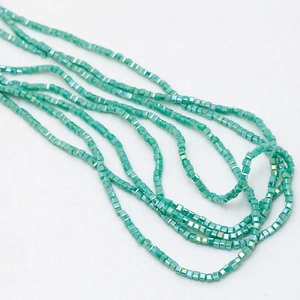 Close-up of 3mm cube crystal beads in lake green with shimmering AB coating for DIY jewelry