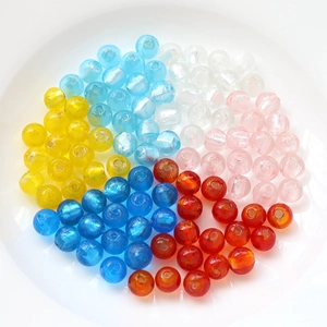 Handmade colorful glass beads for jewelry DIY, smooth round beads on a white plate