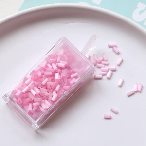 Macro shot of 2mm pink glass tube beads for DIY jewelry making in a plastic box