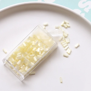 Macro detail of 2mm cream bugle beads in storage box for DIY cross stitch and jewelry