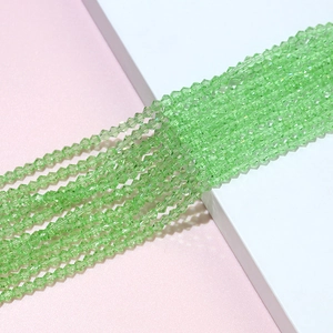 Detailed macro view of 4mm faceted grass green bicone crystal glass beads for jewelry DIY