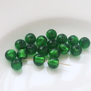 Close-up of emerald green glass beads with gold foil inclusions for DIY jewelry making