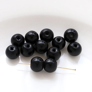 Macro shot of polished black glass beads with gold T-pins for DIY jewelry making
