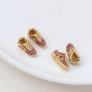 Set of four gold-plated sneaker charms with ruby-purple zircon pave and lace detailing