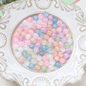 Macro shot of macaron colored crackle glass beads for DIY jewelry making in a ceramic tray