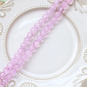 Macro detail of pink purple cracked glass beads on a vintage white ceramic plate