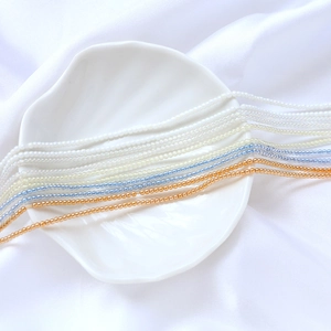 Détail de perles de rocaille de 2mm en verre irisé blanc, bleu et cuivre pour bijoux