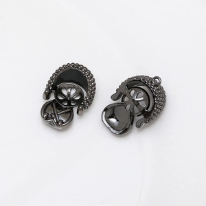 Detail of gunmetal round bead cap jewelry connector with textured surface and loop