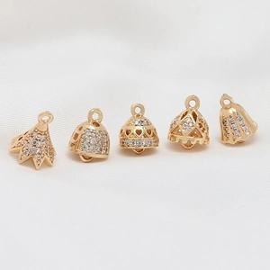 Five assorted 18K gold plated zircon hollow pendant charms for DIY jewelry making on white satin