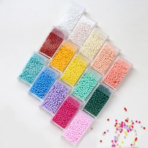 Macro detail of 3mm macaron colorful glass seed beads in transparent storage boxes