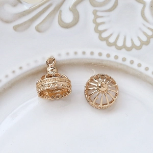 Macro view of gold-plated hollow bell charm with ziconia for DIY jewelry making