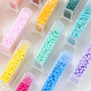 Macro shot of colorful macaron glass seed beads organized in transparent storage cases