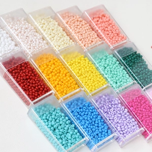 Macro shot of 15-color macaron 3mm glass seed beads organized in a clear craft storage box