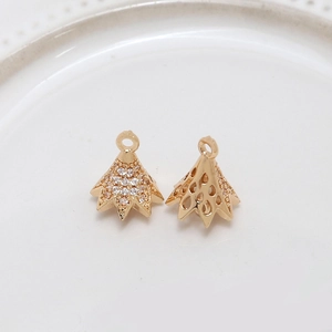 Macro view of gold-plated cone charms with cubic zirconia inlay and hollow teardrop pattern