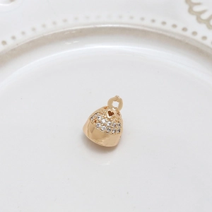 Macro view of gold-plated bell pendant with micro-pave zircons and heart hollow detail