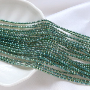 Vue macro de perles de rocaille en verre vert irisé 2mm pour la création de bijoux DIY