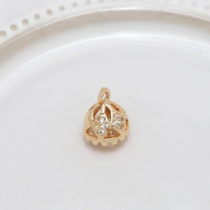Macro shot of gold-plated hollow crown pendant with sparkling zircons for jewelry making