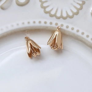 Detailed view of two gold-plated lily flower pendant charms for DIY jewelry making