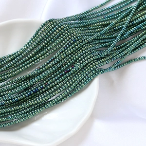Gros plan de perles de rocaille en verre vert iridescent de 2mm pour bijoux DIY