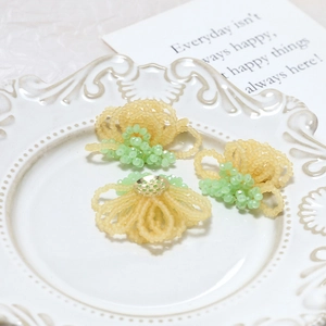 Detailed view of handmade beaded flower charms with crystals and gold lace metal base