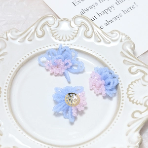 Handmade beaded flower charms with gold metal base for DIY earrings in a decorative plate