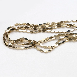 Detailed close-up of golden faceted oval glass beads for DIY jewelry and bracelets