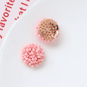 Detalle de colgante de cuentas rosa con base de metal dorado para creación de joyería DIY