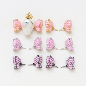 Detail of gold-plated butterfly wing charms with pink enamel and baroque pearl accents