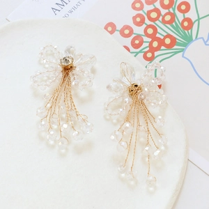 Detail view of crystal beaded flower tassel earrings with intricate woven craftsmanship
