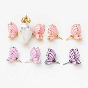 Macro view of Baroque pearl butterfly charm and pink enamel butterfly earrings set
