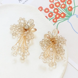 Detail of handmade champagne gold crystal beaded floral earrings with tassels